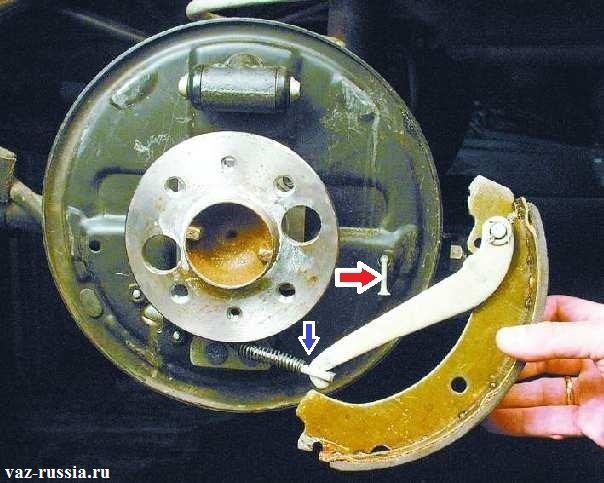 Снятие задней колодки и отсоединение рычага от удерживающей планки которая указана синей стрелкой