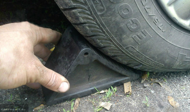 Башмак противооткатный под колесом автомобиля